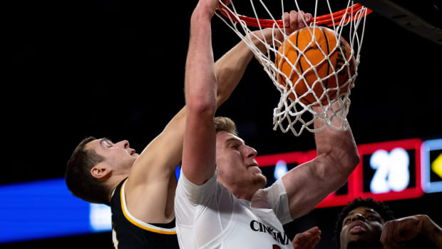 Cincinnati Bearcats forward Viktor Lakhin (30) dunks as Northern Kentucky Norse forward Cade Meyer (10) attempts to stop him in the first half of the NCAA basketball game between the Cincinnati Bearcats and the Northern Kentucky Norse at Fifth Third Arena in Cincinnati on Sunday, Nov. 19, 2023.  © Albert Cesare/The Enquirer / USA TODAY NETWORK